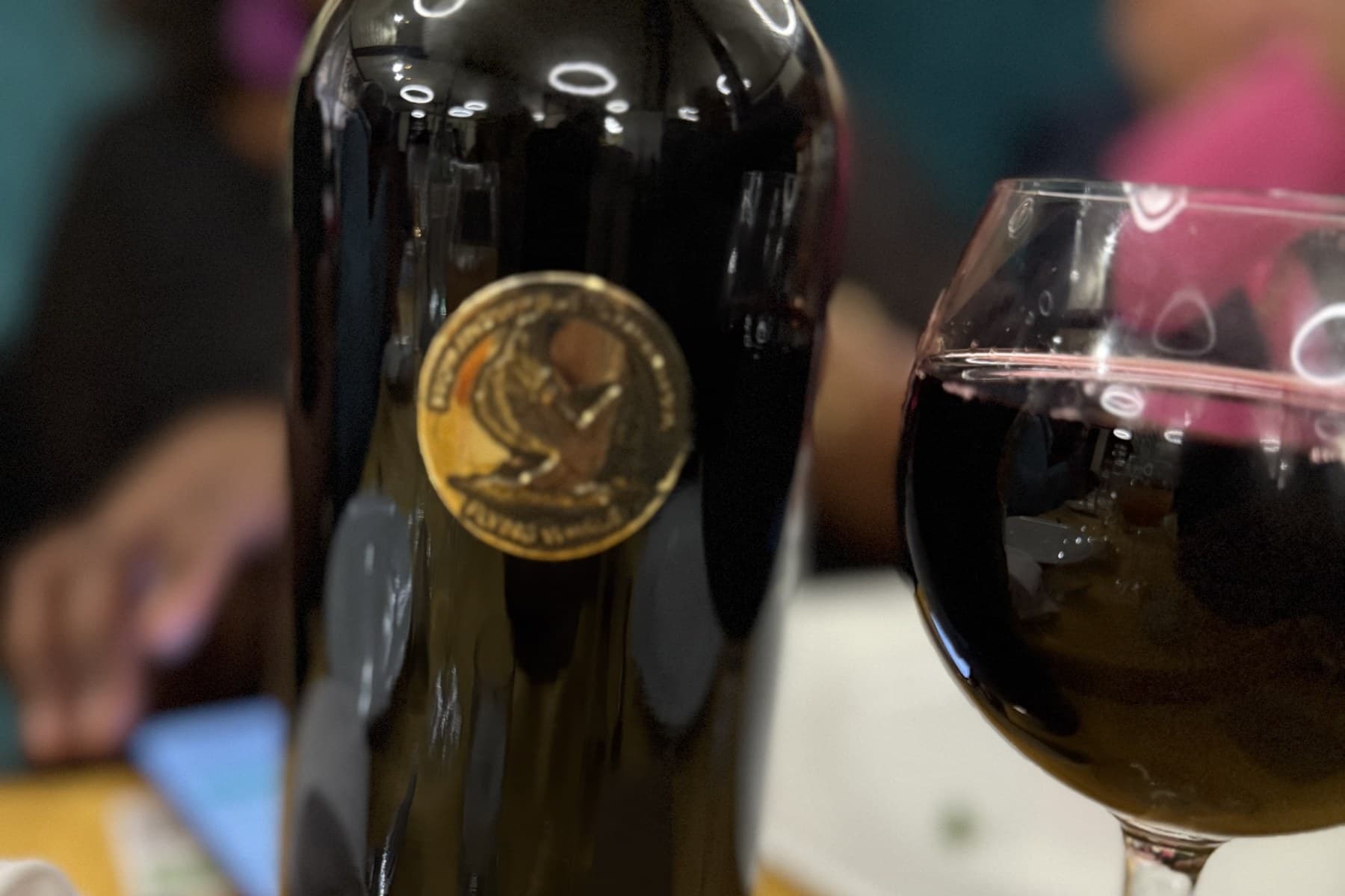 Bottle of red wine and a poured glass during a relaxed evening at the table